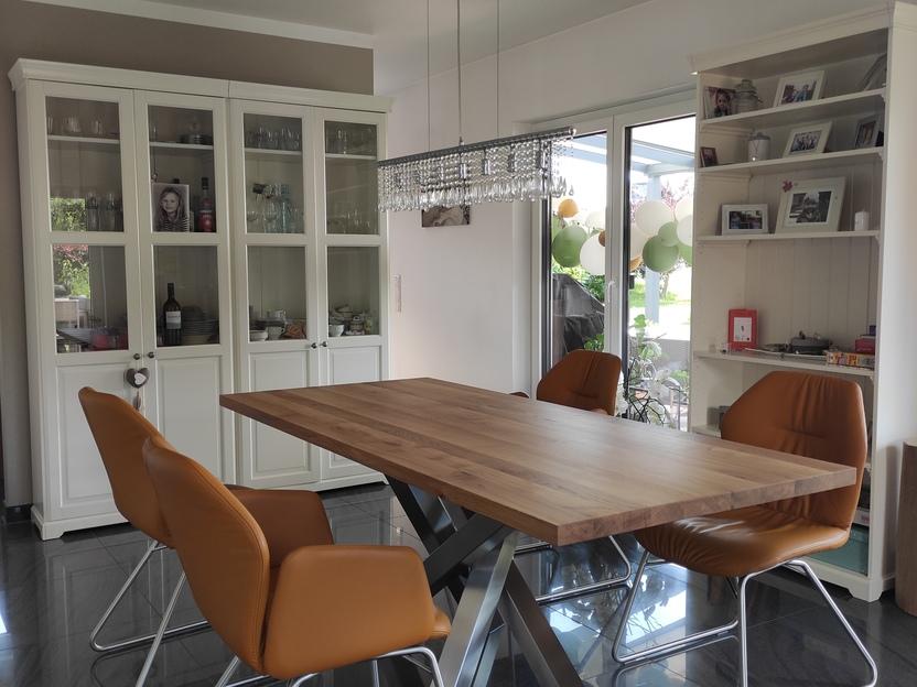 Esszimmer mit Holztisch und Vitrinenschränken von Tischlermeister Thorsten Reinhardt Stilvolles Esszimmer mit maßgefertigtem Holztisch auf Metallgestell, umgeben von Vitrinenschränken und Ledersesseln, ideal für eine elegante und gemütliche Atmosphäre.