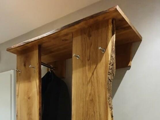Rustikale Garderobe aus massivem Holz mit natürlicher Baumkante, Kleiderhaken und Ablage, ideal für eine stilvolle und natürliche Raumgestaltung.