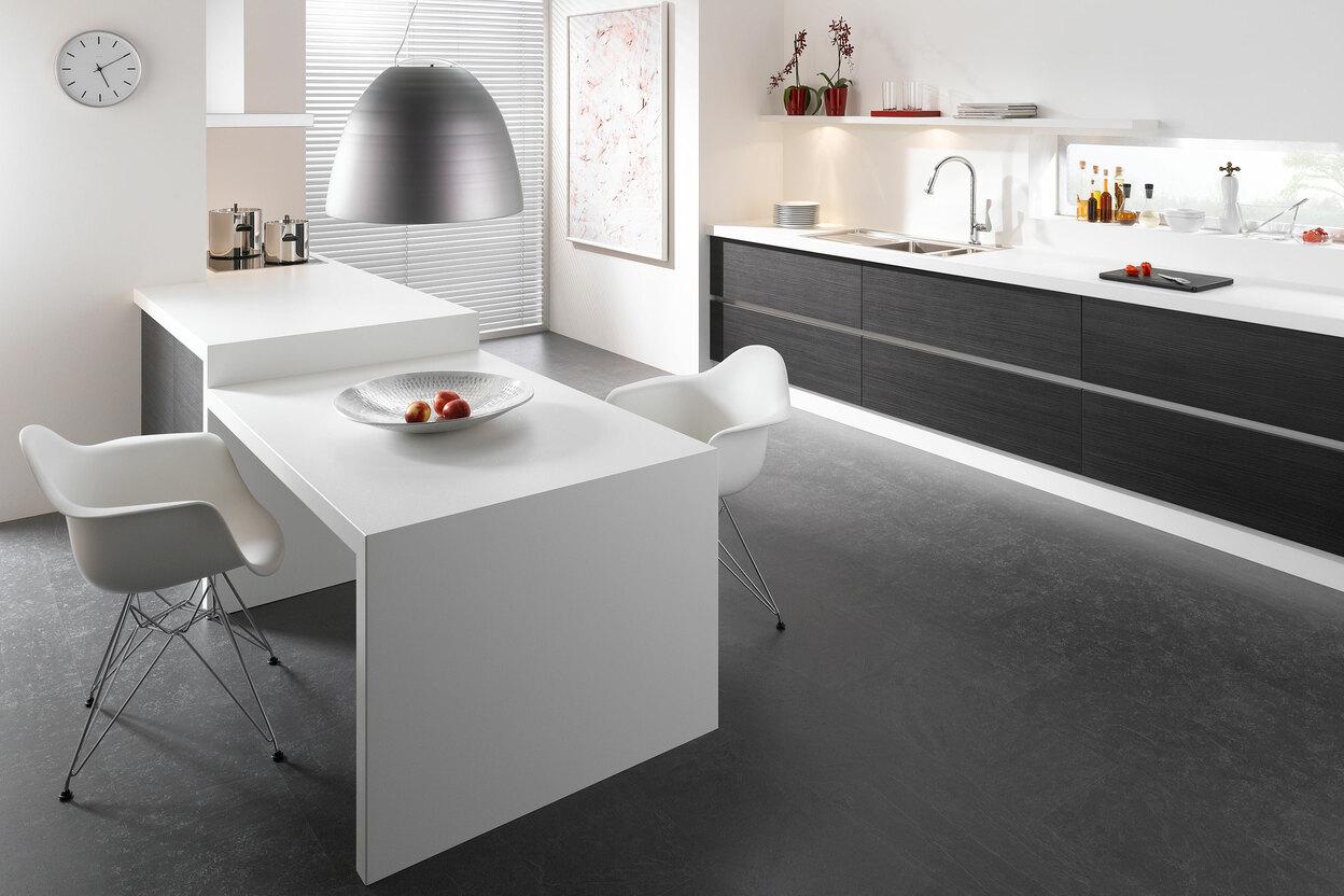 Impression einer einzeiligen Küchengestaltung in schwarz-weiß mit Esstisch für Zwei