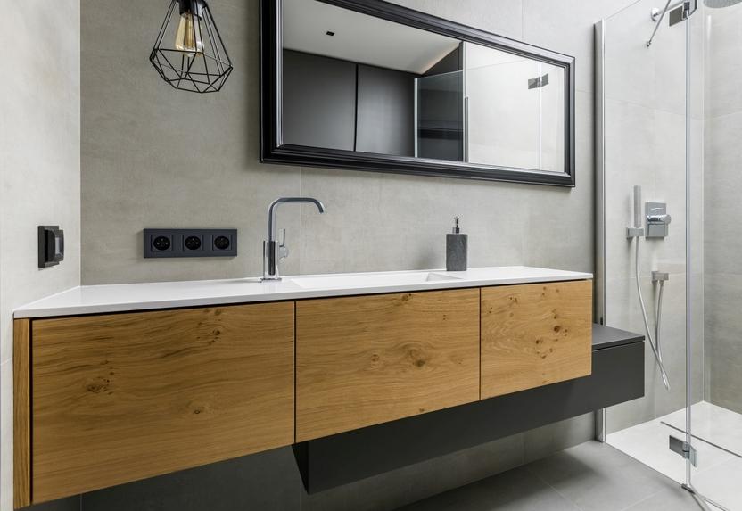 Asymmetrischer Waschtisch mit Schubläden in Echtholz und schwarzer Lackierung auf weiterem schmalen Unterschrank.